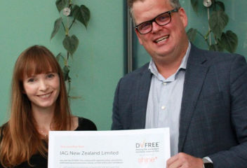 Two people smiling at camera with award for DV Free Shine