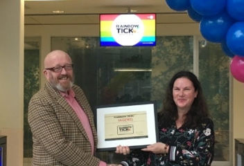 Rainbow Tick Programme Director Michael Stevens hands IAG's Merran Anderson the organisation's certificate